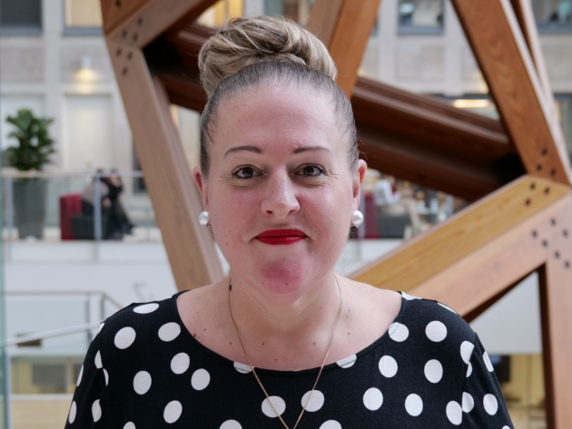 Photo of Sam, wearing a black and white polka dot top