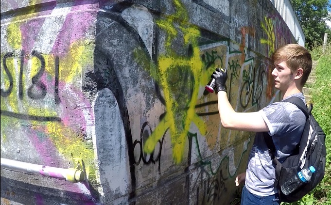 Hannam spray-painting a National Action symbol in Swindon in May 2017