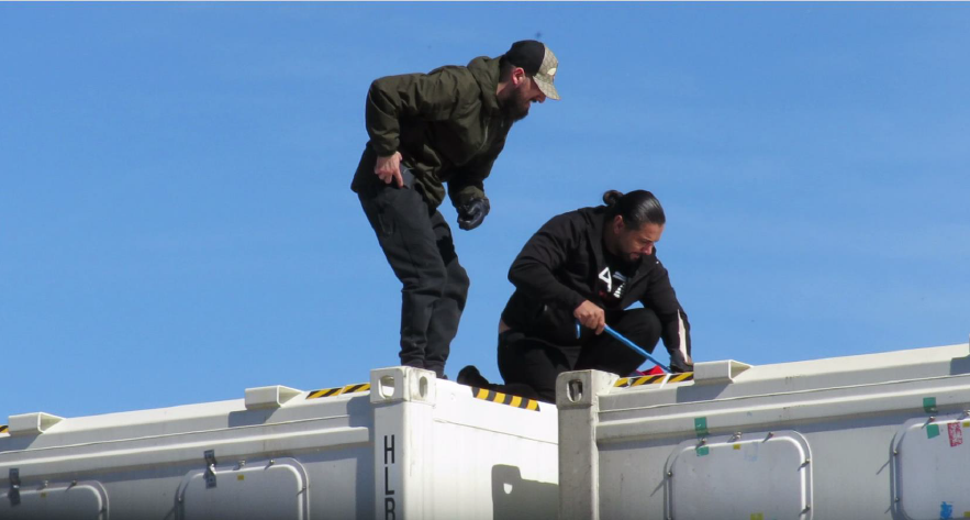 Florjan Ibra (left) and Arman Kaviani (right) seen on top of the container removing the consignment with a crowbar before being arrested