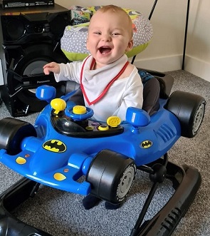 Photo of a smiling Jacob Crouch in a Batmobile bouncer