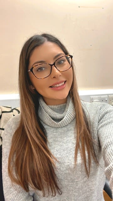 Image (headshot) of CPS employee with long brown hair, wearing glasses and wearing a grey jumper.