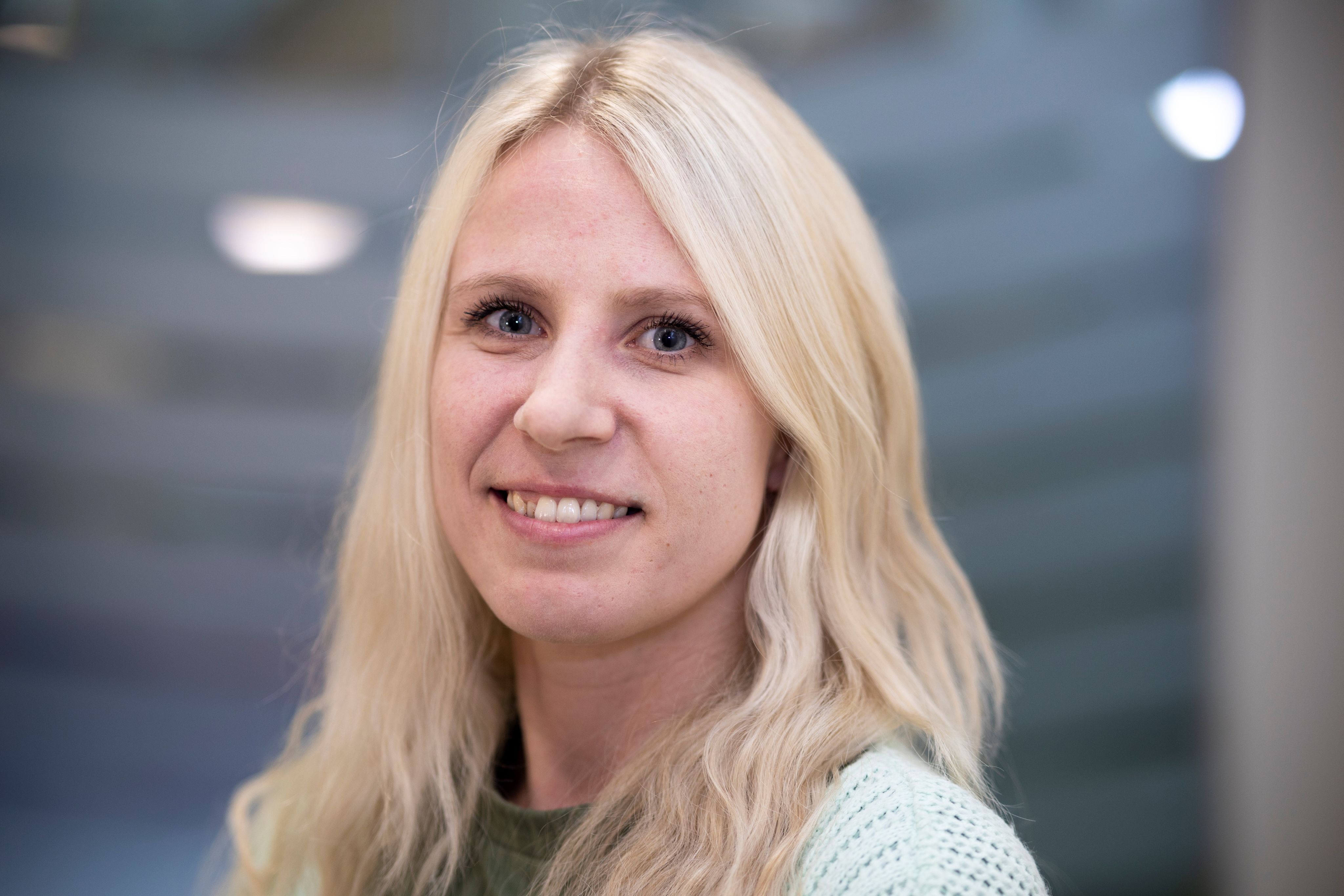 Photo of CPS employee, Ellie-Rose, Casework Assistant. Long blonde hair, wearing a green top and pale green cardigan.