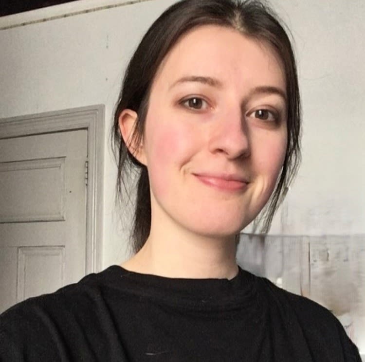 Head and shoulder photo of Isabella. Isabella has dark brown hair that is tied back and wears a black tshirt