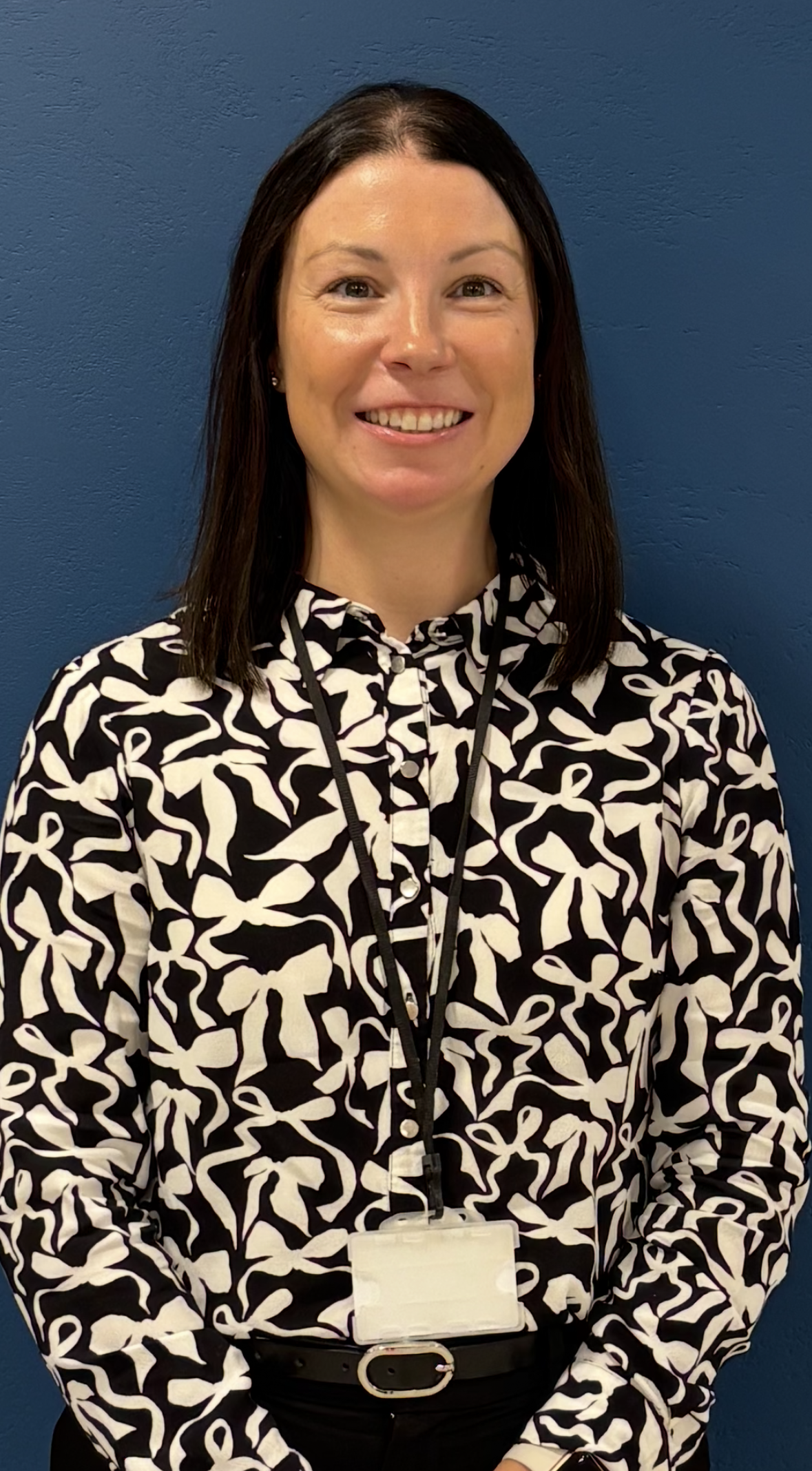 Head and upper body photo of Laura in a patterned shirt.