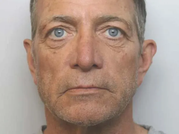 Policy custody image of man wearing grey T-shirt with Cheshire Constabulary logo in top right corner